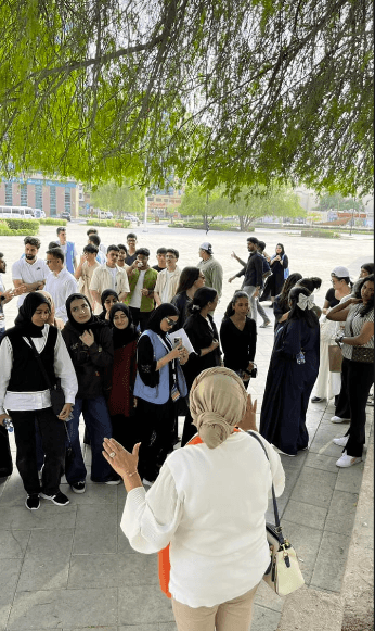 Mona Jebali teaching a group of art students outdoors at a university campus